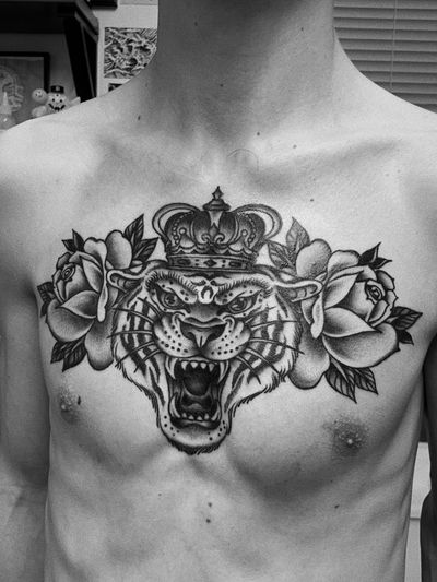 Striking black and gray tattoo by Laurel combining a fierce tiger with a delicate rose in a chicano illustrative style.